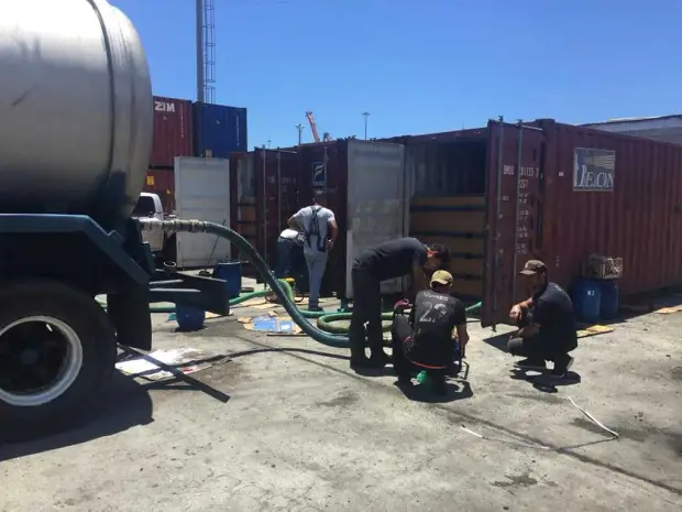 Equipo de Brocicla llenando una cisterna junto a los contenedores