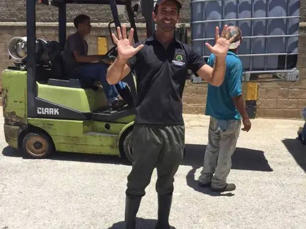 Equipo de Brocicla saludando junto al montacargas en la planta