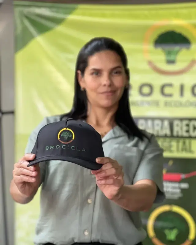 Integrante del equipo de Brocicla mostrando la gorra de la marca en una jornada