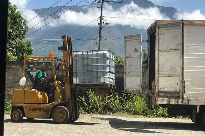 Montacargas cargando un depósito de aceite vegetal usado en un camión