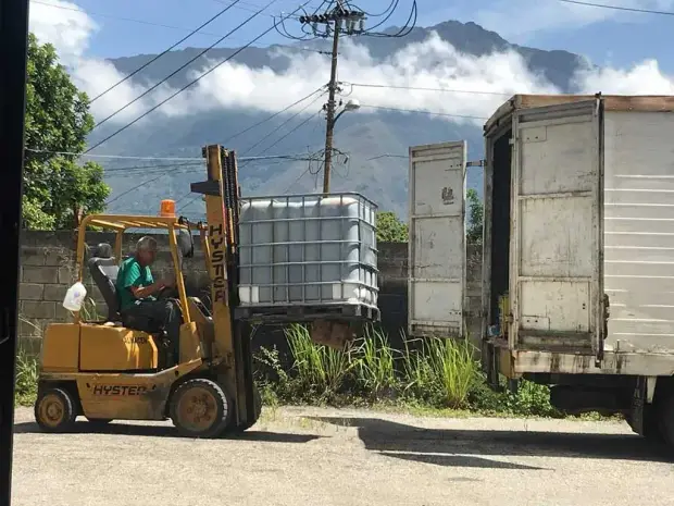 Montacargas cargando un depósito IBC de aceite en un camión