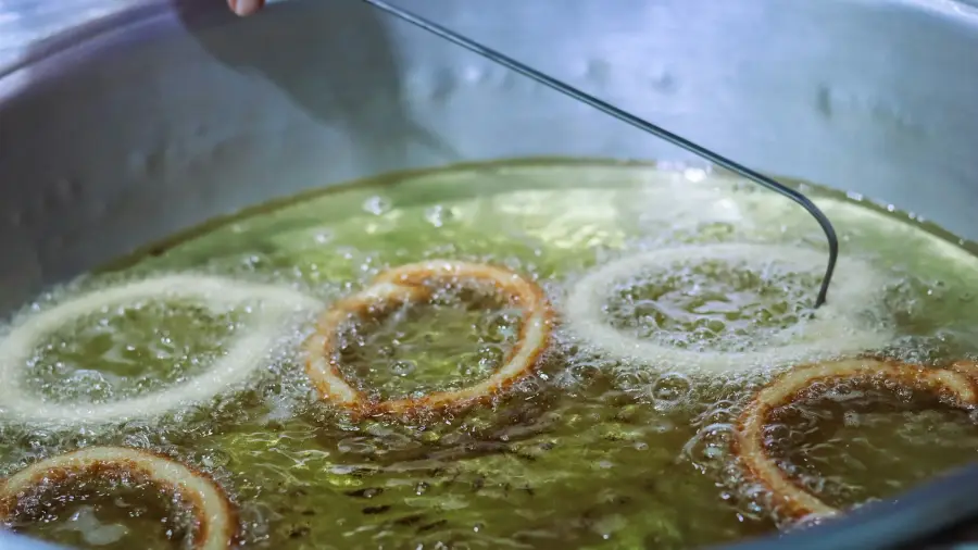 Aros de cebolla friéndose en una olla con aceite